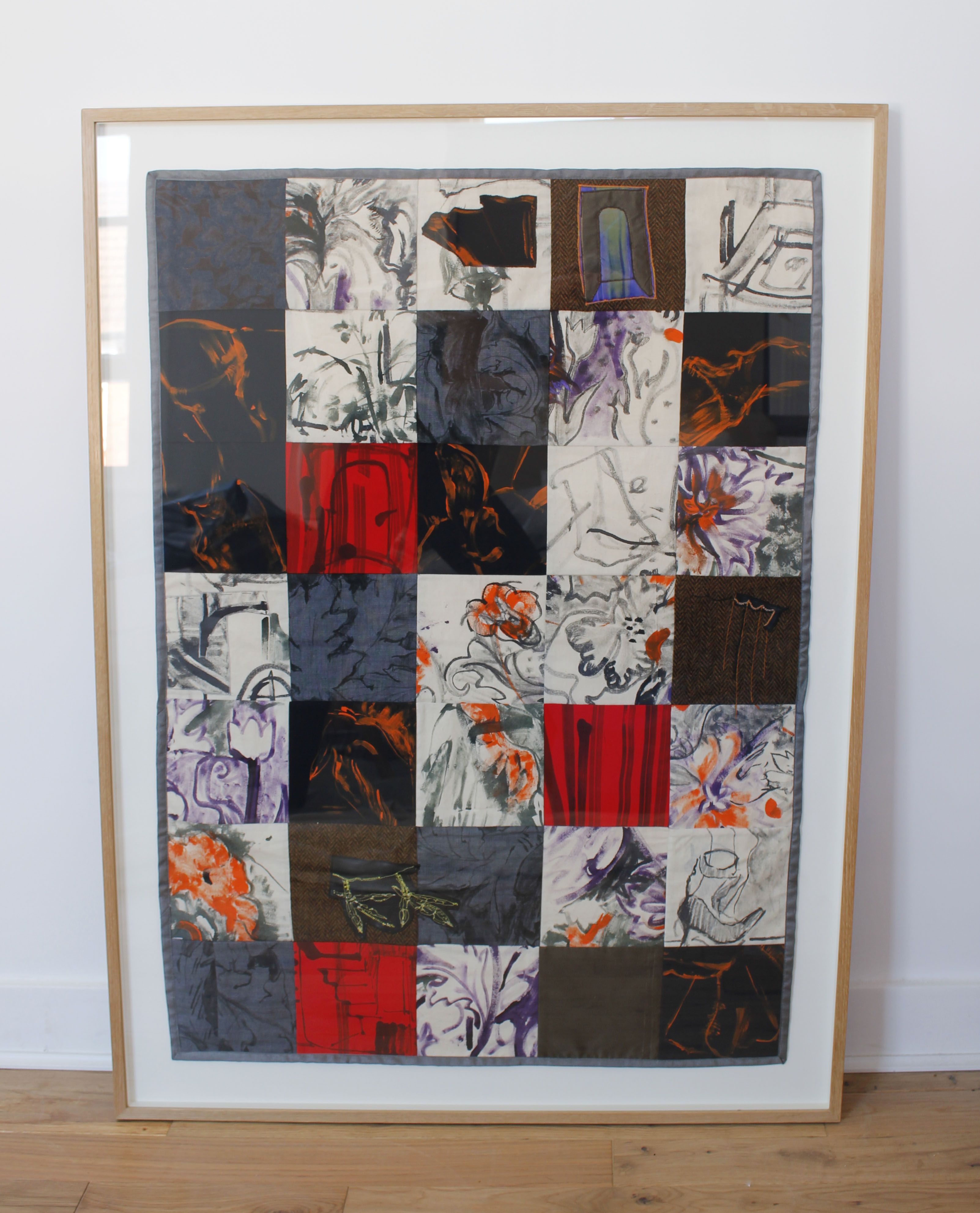 On All Floors, 2020 Framed patchwork wall hanging. Hand painted flowers in purple on canvas, trotters painted in orange on black squares and embroidery of coots feet in yellow thread on black leather   